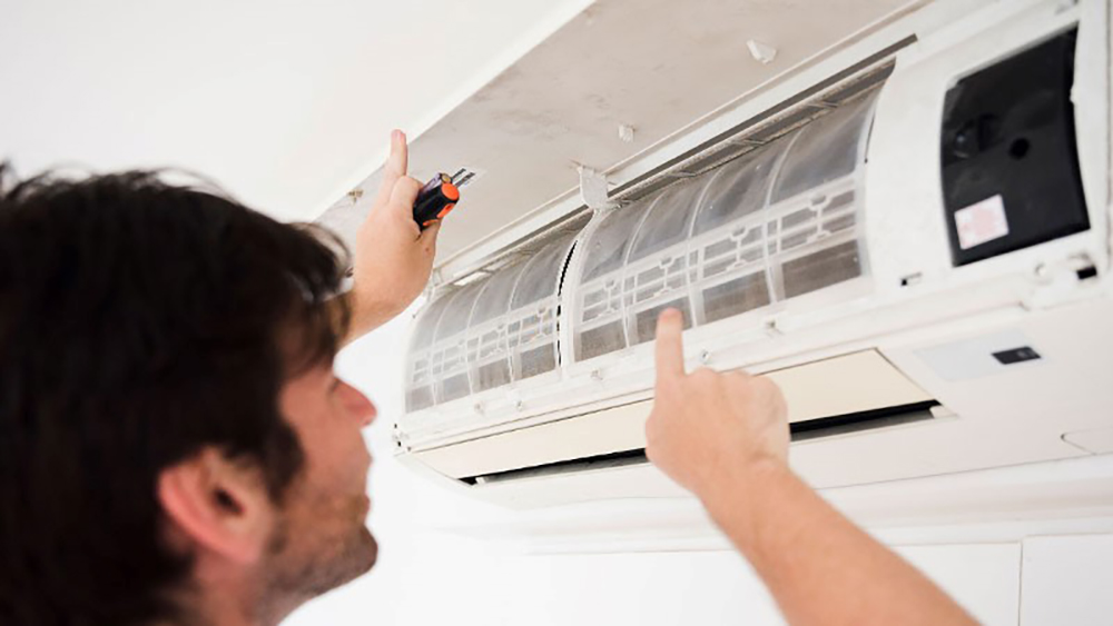 Man repairing AC because Air Conditioner Smells