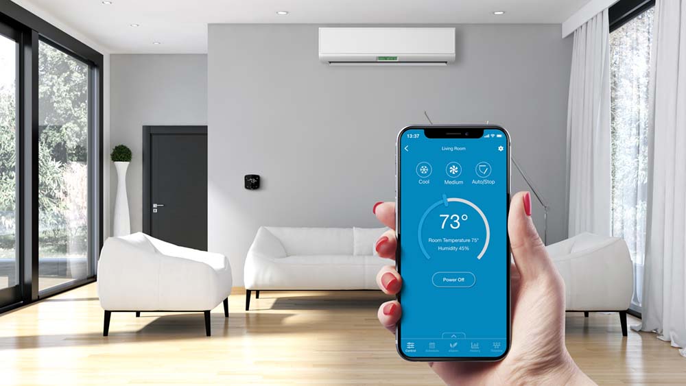 Cielo Breez connected with a mini-split. A woman is using Cielo home app to control the room temperature. 
