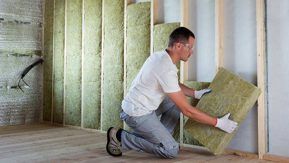 A man insulating exterior wall
