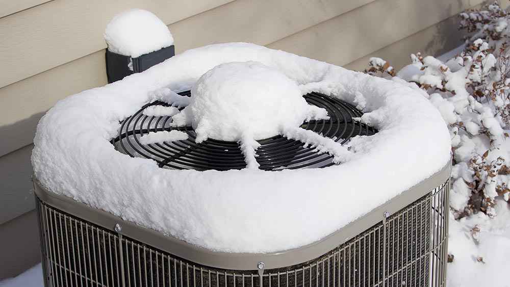 Outdoor air conditioner unit covered in snow