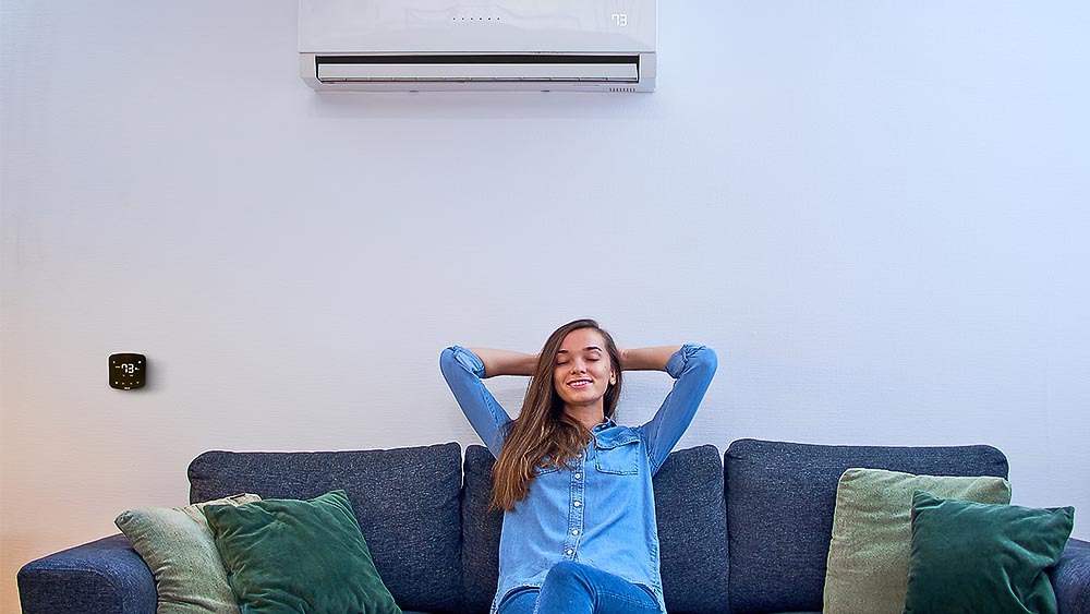 A woman enjoying perfect temperature achieved by a combination of mini-split and Cielo Breez Plus. Mini-split is a perfect air conditioning option for older homes without ductwork