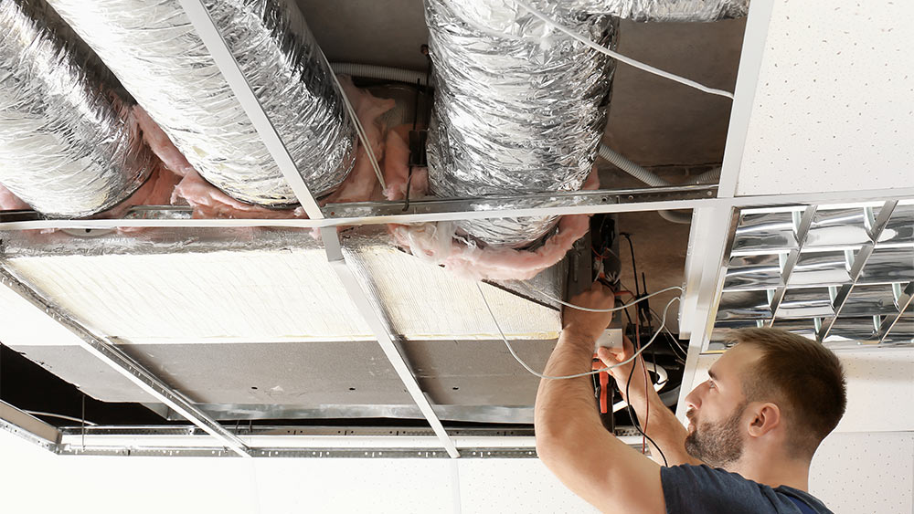 An HVAC technician finding air duct leaks