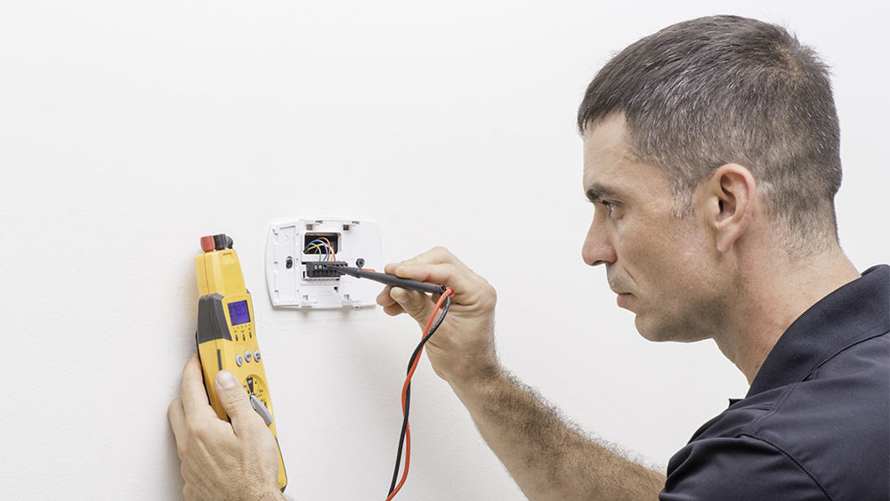 Electrician fixing loose thermsotat wiring