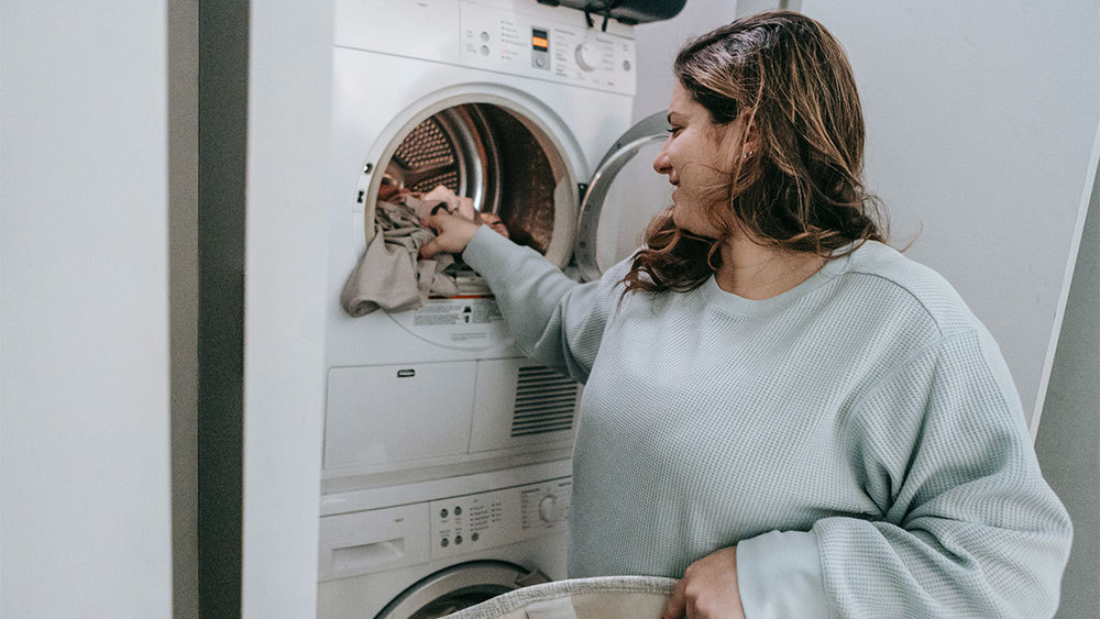 Woman washing clothes in cold water to save on heating bills 