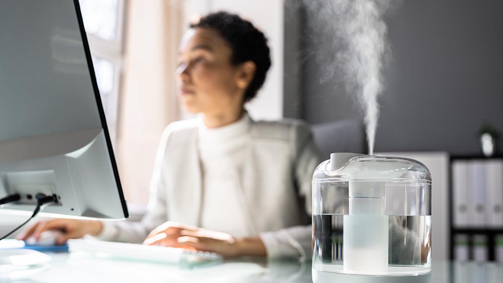 Woman working in her office, a humidifier is placed on the table